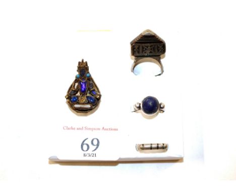 An oriental white metal dress ring; another set coloured stones; and two others 