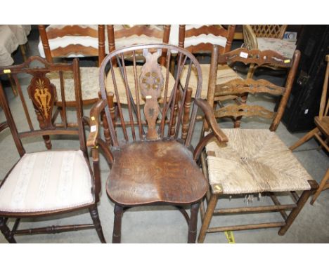 An antique elm seated Windsor stick and wheel back elbow chair with crinoline stretcher