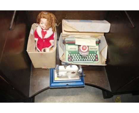 A child's Comet sewing machine; and two dressed dolls; and a Mettoy toy typewriter 