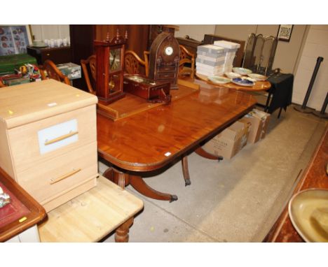 A yew reproduction extending twin pillar dining table; and a set of eight similar dining chairs, (six standards two elbows)