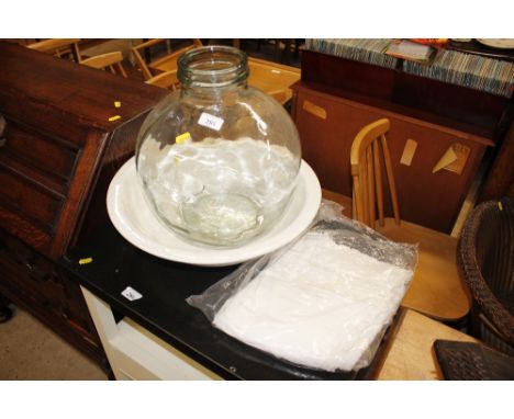 A carboy; a white china wash basin; and two Christening robes