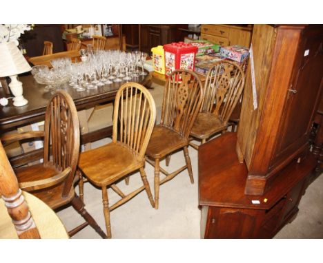 Five elm seated stick and wheelback dining chairs, three standards, two elbows; and a similar stick back chair 