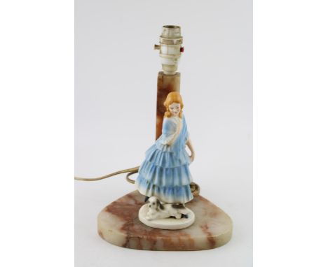 A soapstone lamp base with ceramic figure of lady with dog. Height 28cm.