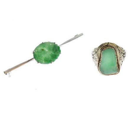 White metal bar brooch having oval carved jade panel, stamped '15ct', together with a filigree design jade set ring stamped '