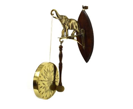 20th Century brass and oak wall-mounted gong, the bracket modelled as an elephant with trunk raised   Condition: 