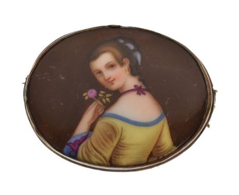 Late 19th/early 20th Century German porcelain oval brooch decorated with a portrait of a young lady holding a flower within b