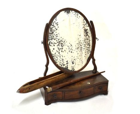 George III mahogany swing dressing mirror having a plain mercury-backed oval mirror plate within shaped surround on a serpent