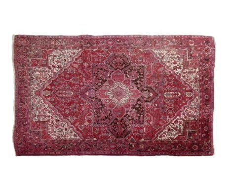 20th Century Persian wool carpet, the red field with central flower head medallion within further flowering plant motifs with