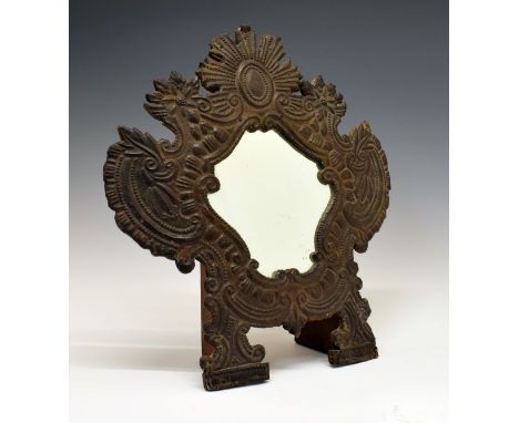 Continental embossed leather dressing table mirror, the shield shaped plate within a surround of scrolls and sunburst on a wo