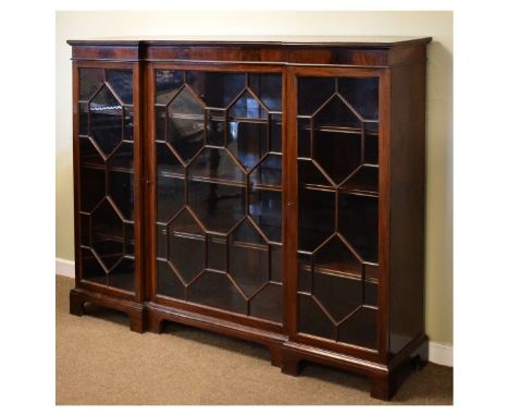 Reproduction mahogany inverted breakfront bookcase fitted three astragal glazed doors and standing on bracket feet   Conditio