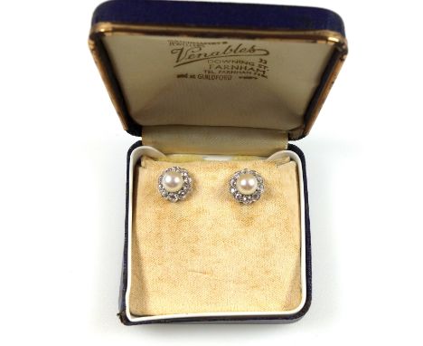 Pair of white metal earrings, stamped 750, each set with a pearl, 6-7mm, enclosed by 10 diamonds, together .7cts approx., 4 g