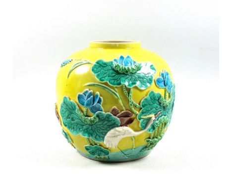 Chinese earthenware ginger jar with a wading stork and water lilies in relief on a mustard yellow ground, with impressed 4 ch