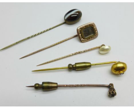 Five stick pins including yellow metal and tigers eye 