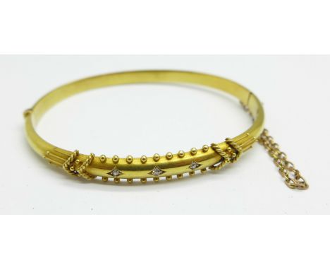 A 15ct gold and three stone set bangle with box, 7.4g 