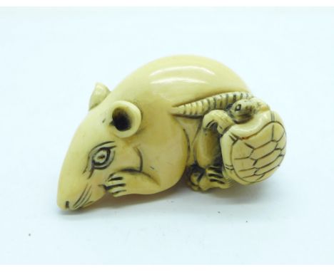 A carved ivory netsuke of a rat with tortoise 