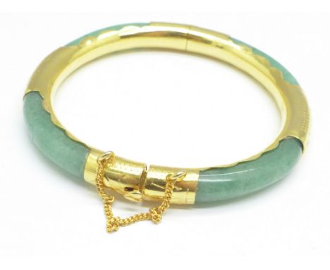 A gilt metal and jade bangle 