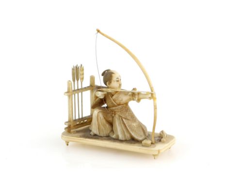 A small ivory okimono of a kneeling archer pulling a yumi,  5cm high, Meiji Period, contained in a Tiffany &amp; Co. box (2)T