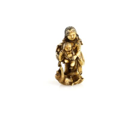 A stained ivory netsuke of Benten holding a child; a monkey playing beside them, 19th or 20th CenturyProvenance: The Property