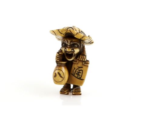 A stained ivory netsuke of a tanuki, or other mythological sake vendor, wearing geta; with a sake bottle in the right hand an