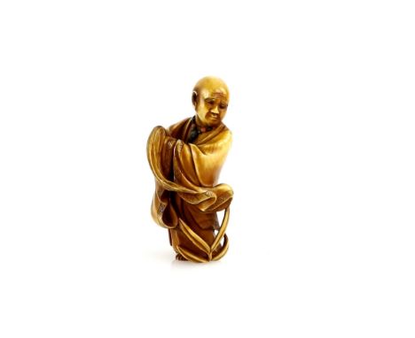 A stained ivory netsuke of The Bodhidharma, Daruma standing on a reed, signed Gyokko, 20th CenturyProvenance: The Property of