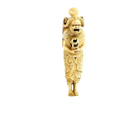 A tall stained ivory netsuke carved as Ryujin's attendant, wearing the Octopus head dress and holding the hoju-no-tama with b