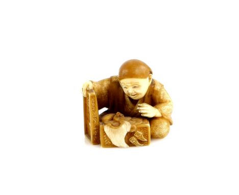 A dark stained ivory netsuke of a man taking the lid from a box of treasure, 20th CenturyProvenance: The Property of a Lady. 