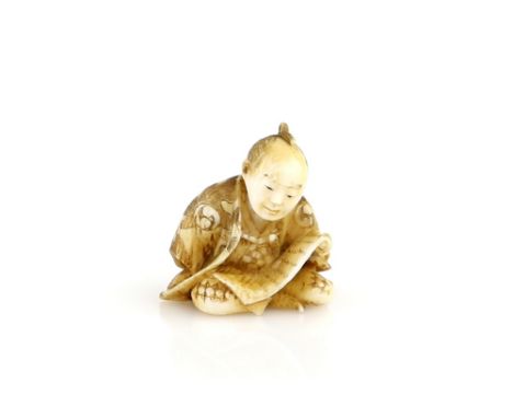 A stained ivory netsuke of a man reading a makemono, 19th or 20th CenturyProvenance: The Property of a Lady. From a Private C