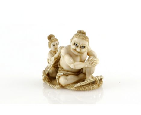 A stained ivory netsuke carved as a Yamato Nadeshko cleaning a large Nio whilst sitting on a large waraji, signed on a red re