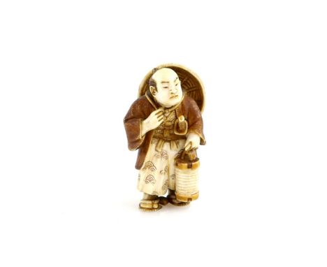 A stained ivory netsuke of a standing man with a jingasa on his back and a lantern in his left hand; 20th century Provenance: