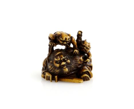 A stained ivory netsuke of Shoki, trapped by two Oni, 20th CenturyProvenance: The Property of a Lady. From a Private Collecti