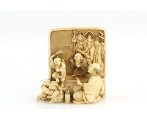 A stained ivory okimono carved as  a seated screen maker, looking with surprise as members of The Shichifukjin come to life f