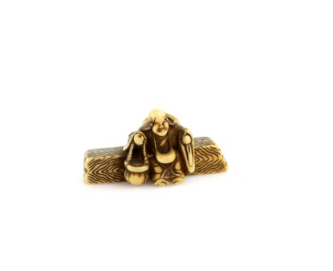 A stained ivory netsuke of the famous Heian Waka Poetess, Ono no Komachi, seated on a log with a jingasa on her back, 5 cm lo