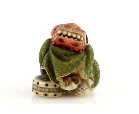 A Yasuaki (Homei) School coloured ivory netsuke carved as a Shishimai Dancer beside a drum; the lower jaw of the costume arti