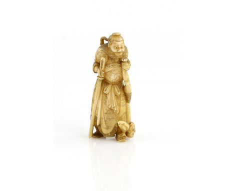 A stained ivory okimono of Shoki, The Demon Queller, holding his sword and keeping an Oni underfoot, 8.5 cm high, 20th Centur