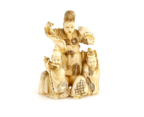 A stained ivory okimono carved as three actors from The Noh Drama, or from another theatre; one figure with a hand drum and o