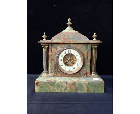 A FIGURED ONYX MANTEL CLOCK of architectural form, with French movement striking on a gong 33cm wide
