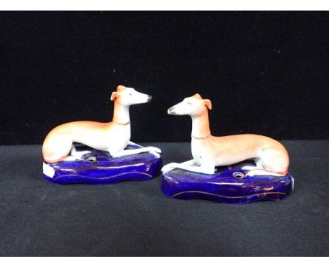 A PAIR OF STAFFORDSHIRE GREYHOUND INKWELLS with cobalt blue bases, one with painted '8' mark, 16cm wide (tiny chip to ear, li