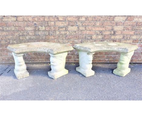 A PAIR OF RECONSTITUTED STONE GARDEN BENCHES with curved tops supported by stylised squirrel bases, each bench 100cm wide (ch