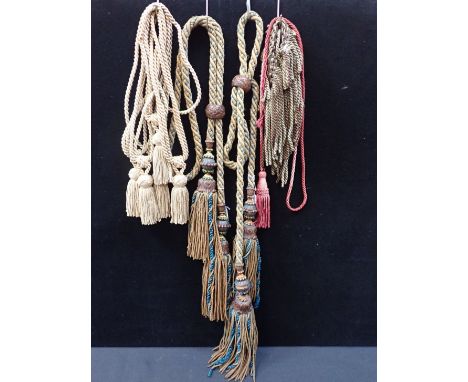 A PAIR OF CARVED OAK TASSLED CURTAIN TIE BACKS with others