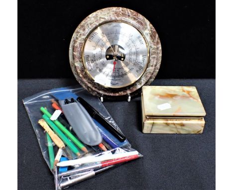 A BAROMETER IN A SERPENTINE MOUNT with an onyx box and a collection of pens and pencils