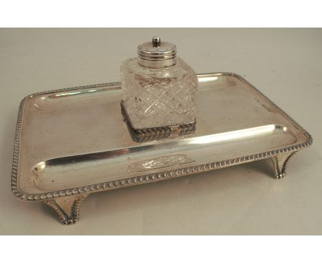 A silver desk stand, of rectangular form, with gadrooned edge, having two pen wells and fitted with a square glass and silver