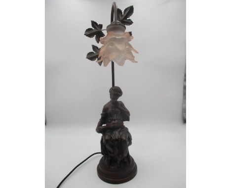 An Art Nouveau style lamp in the form of a lady reading a book.
