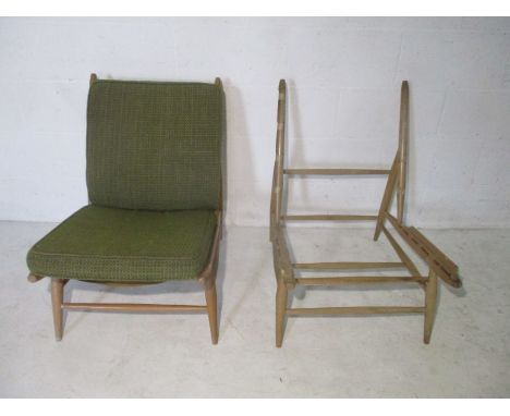 A pair of Ercol Model 427, lounge chairs. One has original upholstered cushions, the other is frame only.