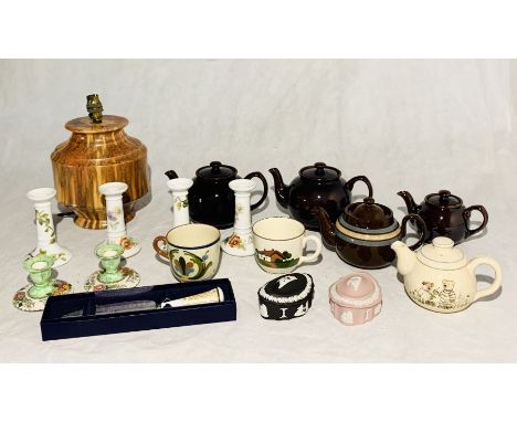 A collection of china including Limoges candle sticks, Wedgwood, various tea pots and a pottery lamp on two shelves