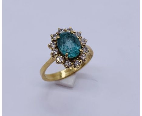 A diamond and emerald cluster ring set in 18ct gold- the emerald measuring approx. 9mm x 7mm