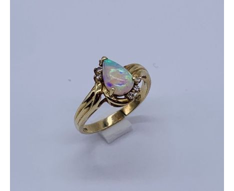 A 14ct gold ring set with a pear shaped opal and diamonds