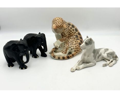 A ceramic USSR marked leopard and dog (possibly Great Dane) along with two wooden elephants 