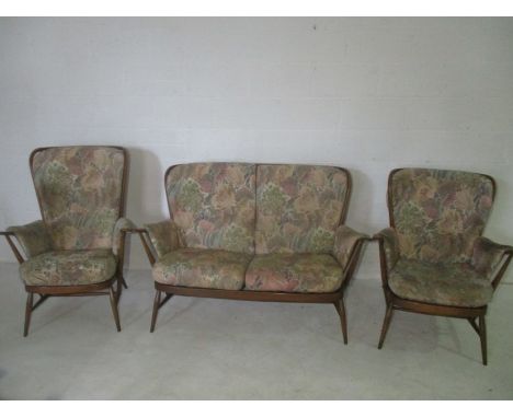 An Ercol mid century Golden Dawn three piece suite with foot stool. Also includes one extra cushion and two arm covers.