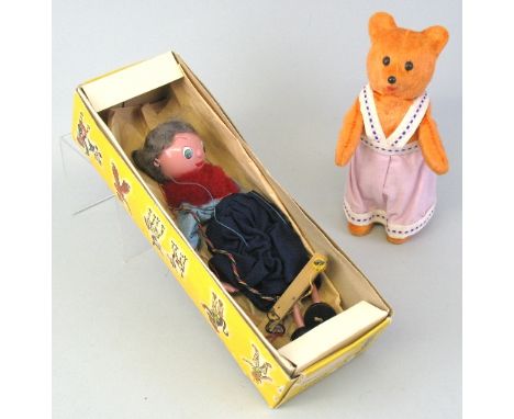 A Pelham Puppet, "Grandmother" in original box and a clockwork teddy bear figure wearing a pink dress, 24cm high (2)