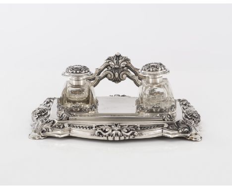 A silver inkstandSilver, fineness .833With cut-glass inkwell and pounce pot, and letter rackRelief decoration with foliage mo